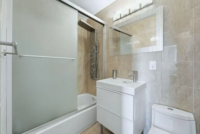 a bathroom with a sink a toilet a shower and a mirror