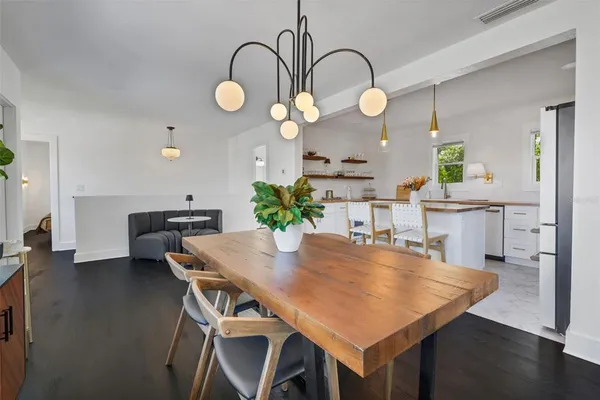 a view of a kitchen with kitchen island a large window cabinets a sink and stainless steel appliances