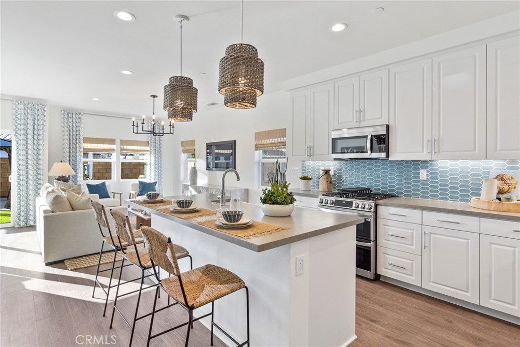 12352 Van Gogh Place Yucaipa, CA 92399 - Photo 13 of 44 a kitchen with kitchen island granite countertop a sink cabinets and stainless steel appliances