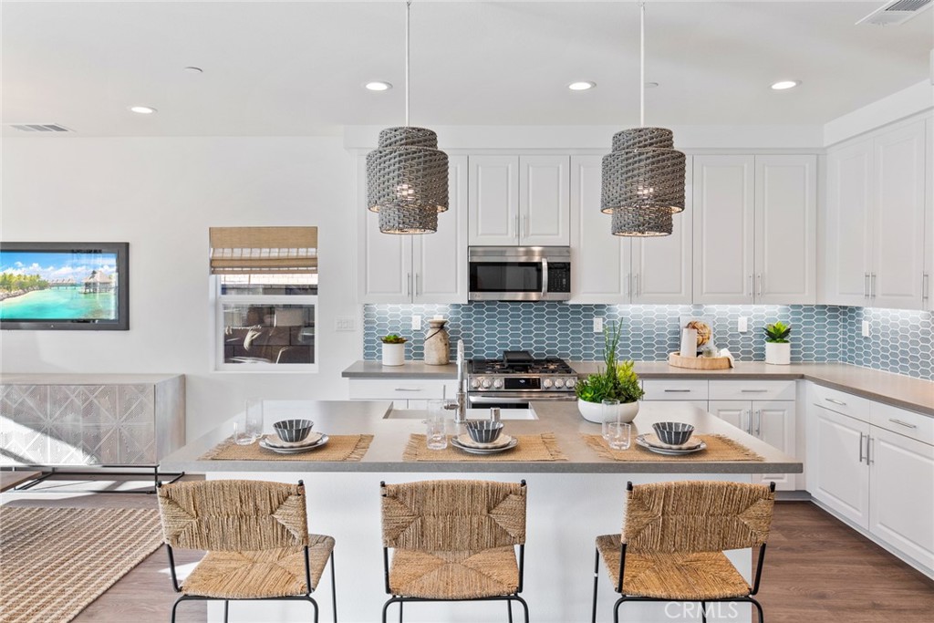 12352 Van Gogh Place Yucaipa, CA 92399 - Photo 20 of 44 a kitchen with stainless steel appliances kitchen island granite countertop a sink and cabinets