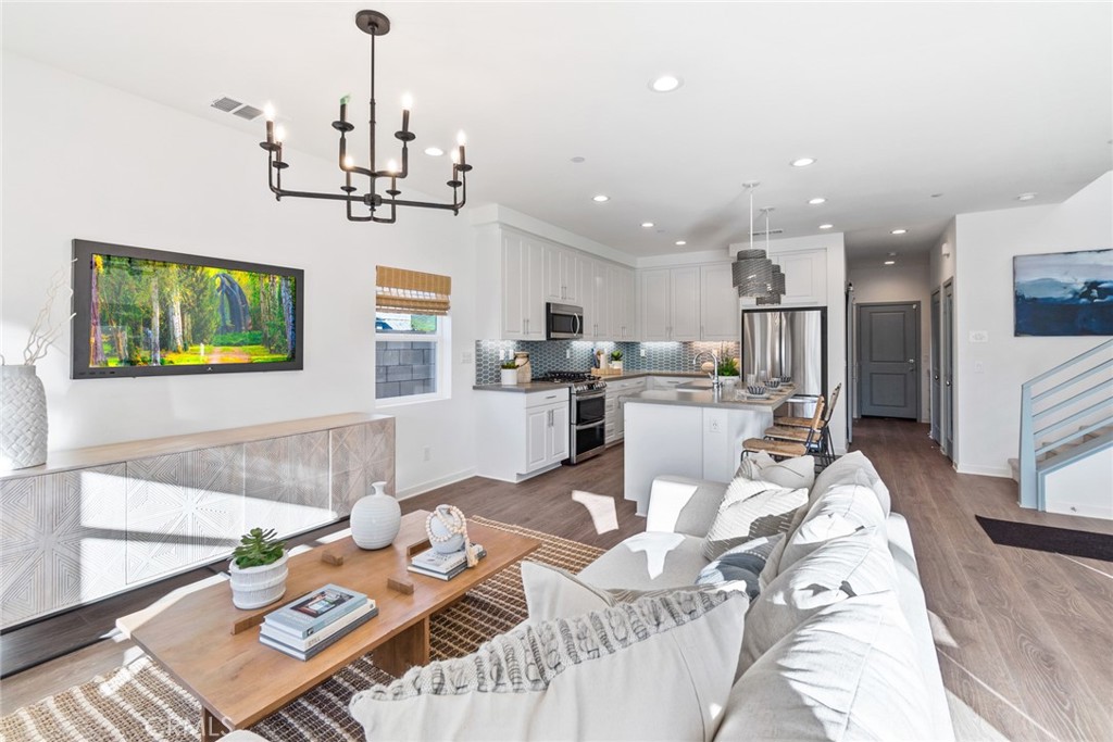 12352 Van Gogh Place Yucaipa, CA 92399 - Photo 10 of 44 a view of a dining room and livingroom with furniture wooden floor a chandelier