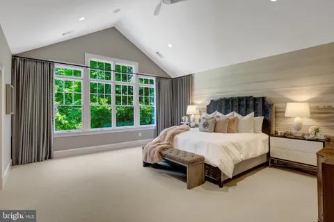 a large bed sitting in a room next to a window