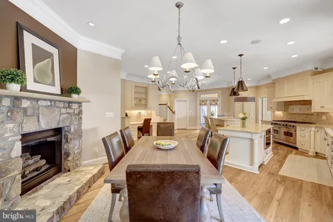 a view of a dining room with furniture a fireplace and wooden floor