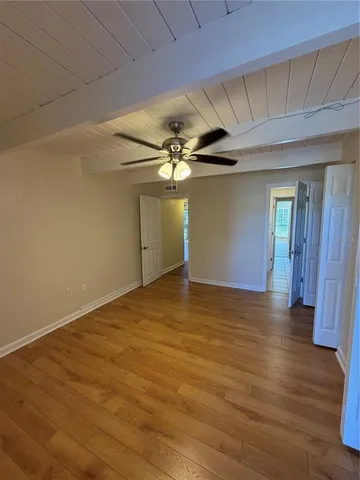 a view of a livingroom with wooden floor and a ceiling fan