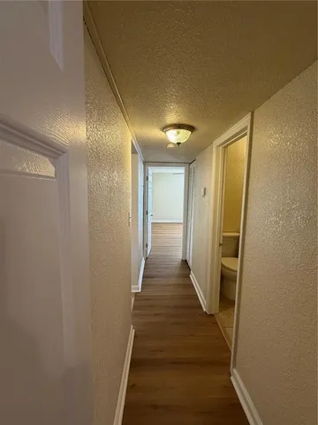 a view of a hallway with wooden floor and staircase