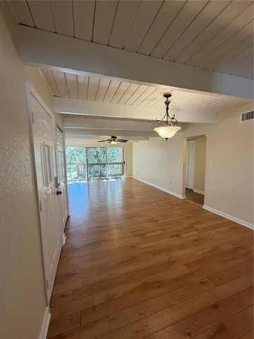 a view of empty room with wooden floor