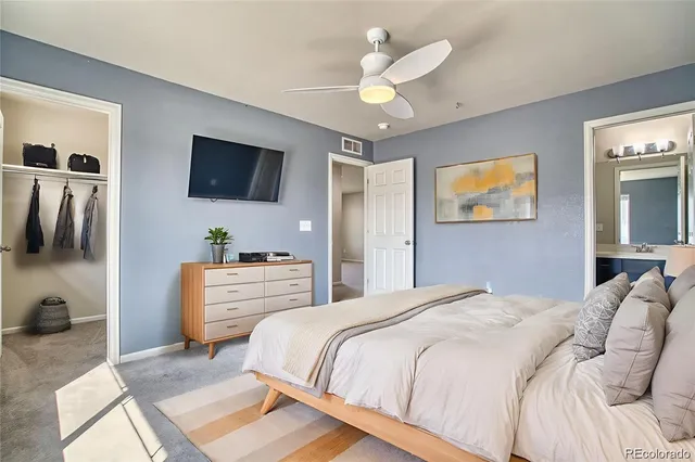 a bedroom with a bed a flat screen tv and a window