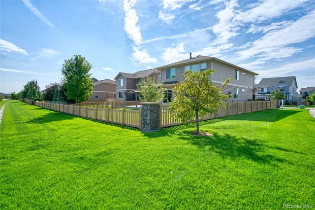 a backyard of a house with plants and wooden fence