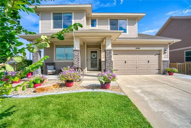 a front view of a house with a yard and a garage
