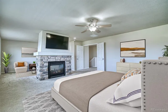 a spacious bedroom with a bed and a fireplace