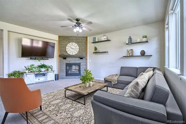 a living room with furniture a flat screen tv and a large window
