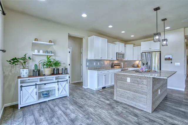 a kitchen with wooden floors and wooden cabinets