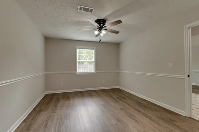 an empty room with a window and a ceiling fan