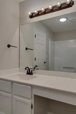 a bathroom with a sink a mirror and shower
