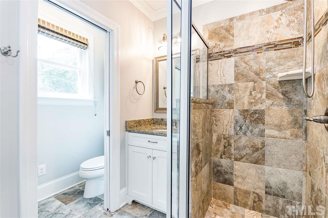 2513 Stafford Avenue Raleigh, NC 27607 - Photo 14 of 30 a bathroom with a granite countertop shower a toilet and a shower