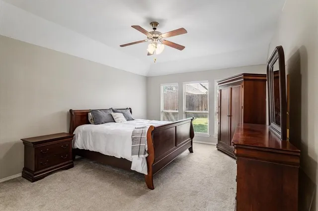 a spacious bedroom with a bed dresser and a window
