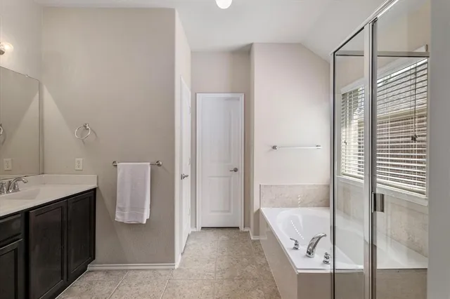 a bathroom with a tub sink and mirror