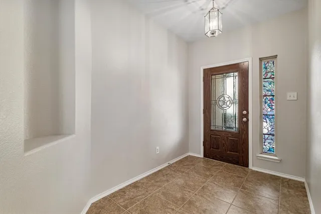an empty room with windows mirror and fan