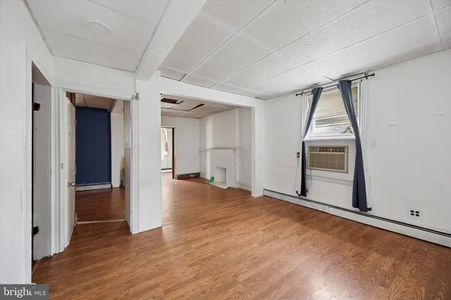 a view of a big room with wooden floor and windows