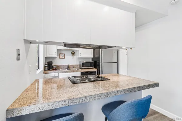 a kitchen with granite countertop kitchen island stainless steel appliances a sink and a counter top space