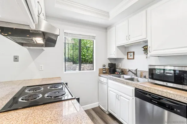a kitchen with stainless steel appliances granite countertop a sink stove and cabinets