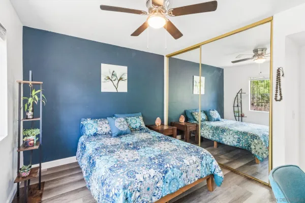 a bedroom with bed and wooden floor