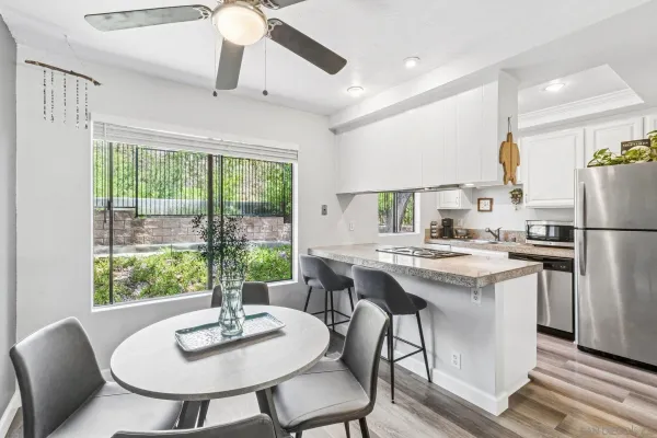 a kitchen with a dining table chairs and refrigerator