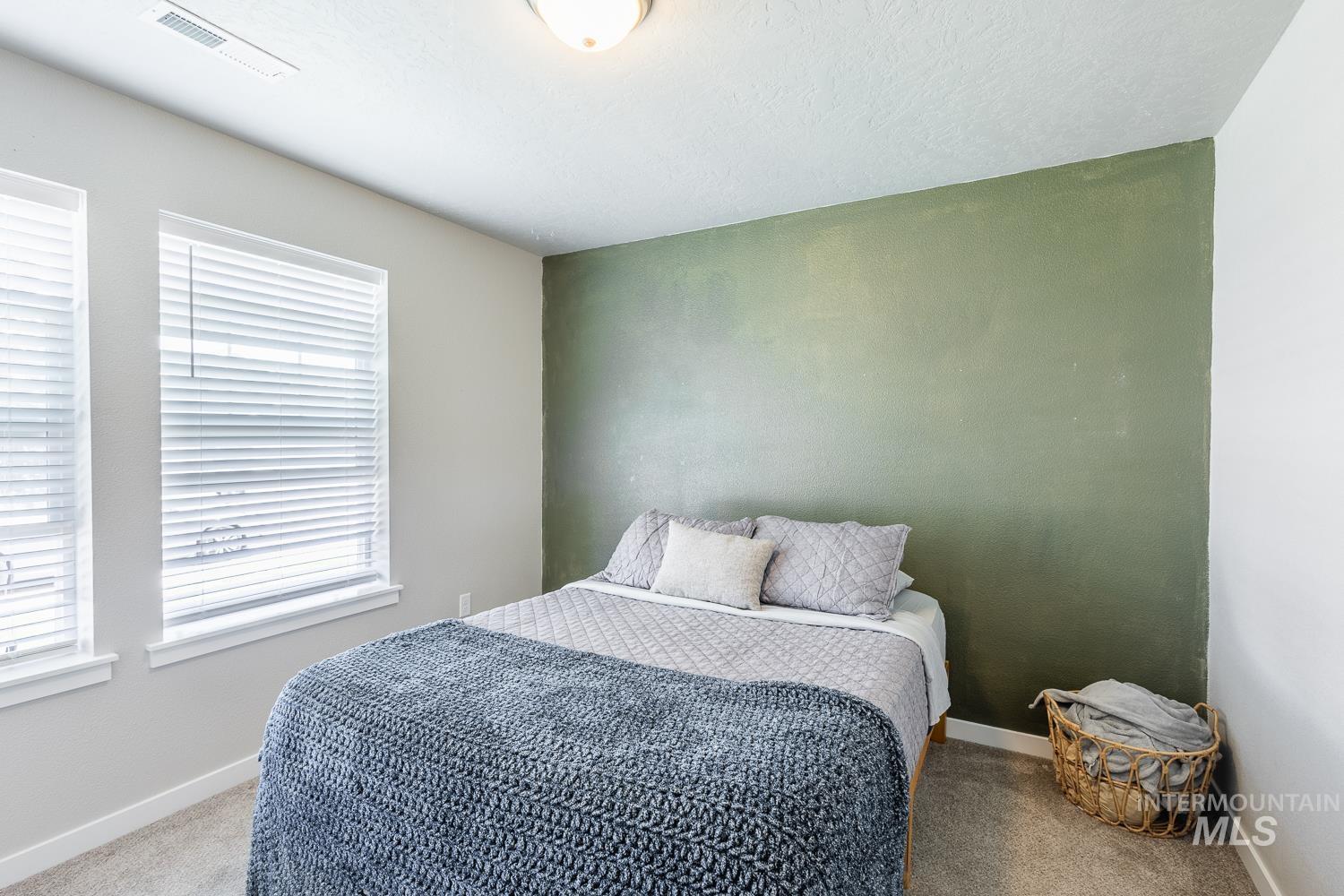 12623 Shadow Peak Street Caldwell, ID 83607 - Photo 35 of 50 Bedroom featuring a textured accent wall and light gray carpeting