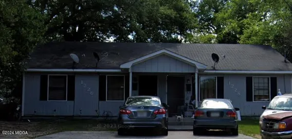 a couple of cars parked in front of a house