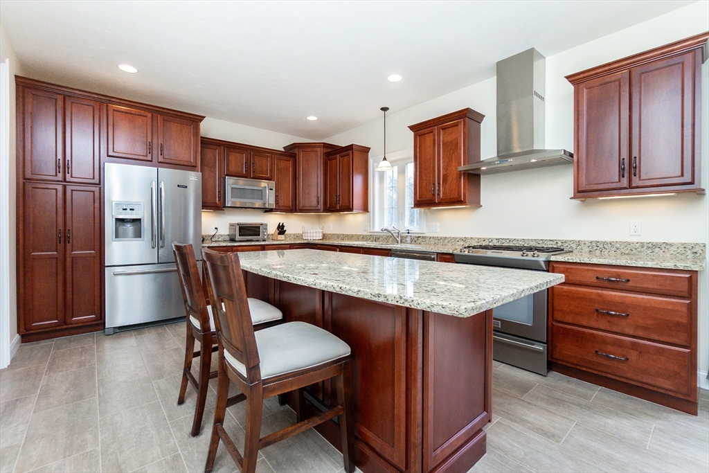 31 Whitehall Way Bellingham, MA 02019 - Photo 3 of 39 a kitchen with granite countertop wooden floors and wooden cabinets