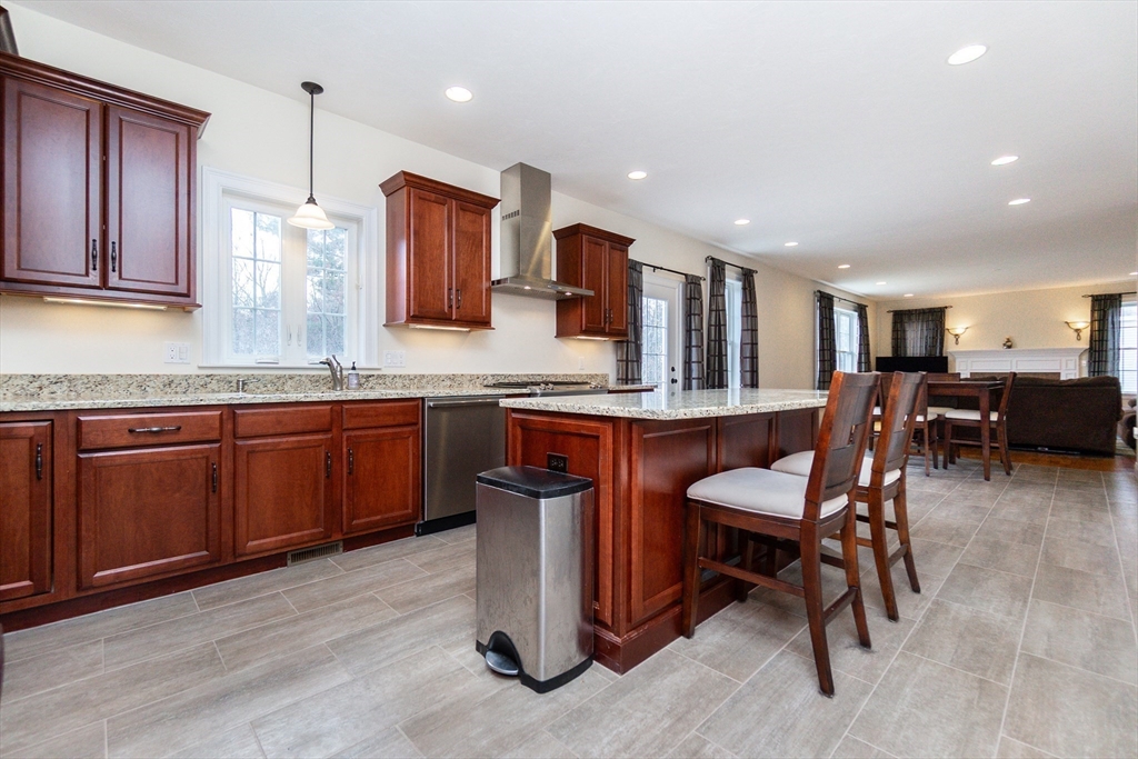 31 Whitehall Way Bellingham, MA 02019 - Photo 5 of 39 a kitchen with stainless steel appliances granite countertop wooden cabinets a dining table and chairs