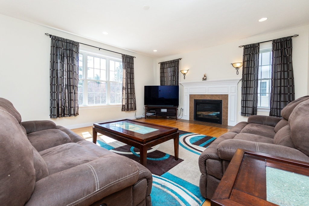 31 Whitehall Way Bellingham, MA 02019 - Photo 10 of 39 a living room with furniture a flat screen tv and a fireplace