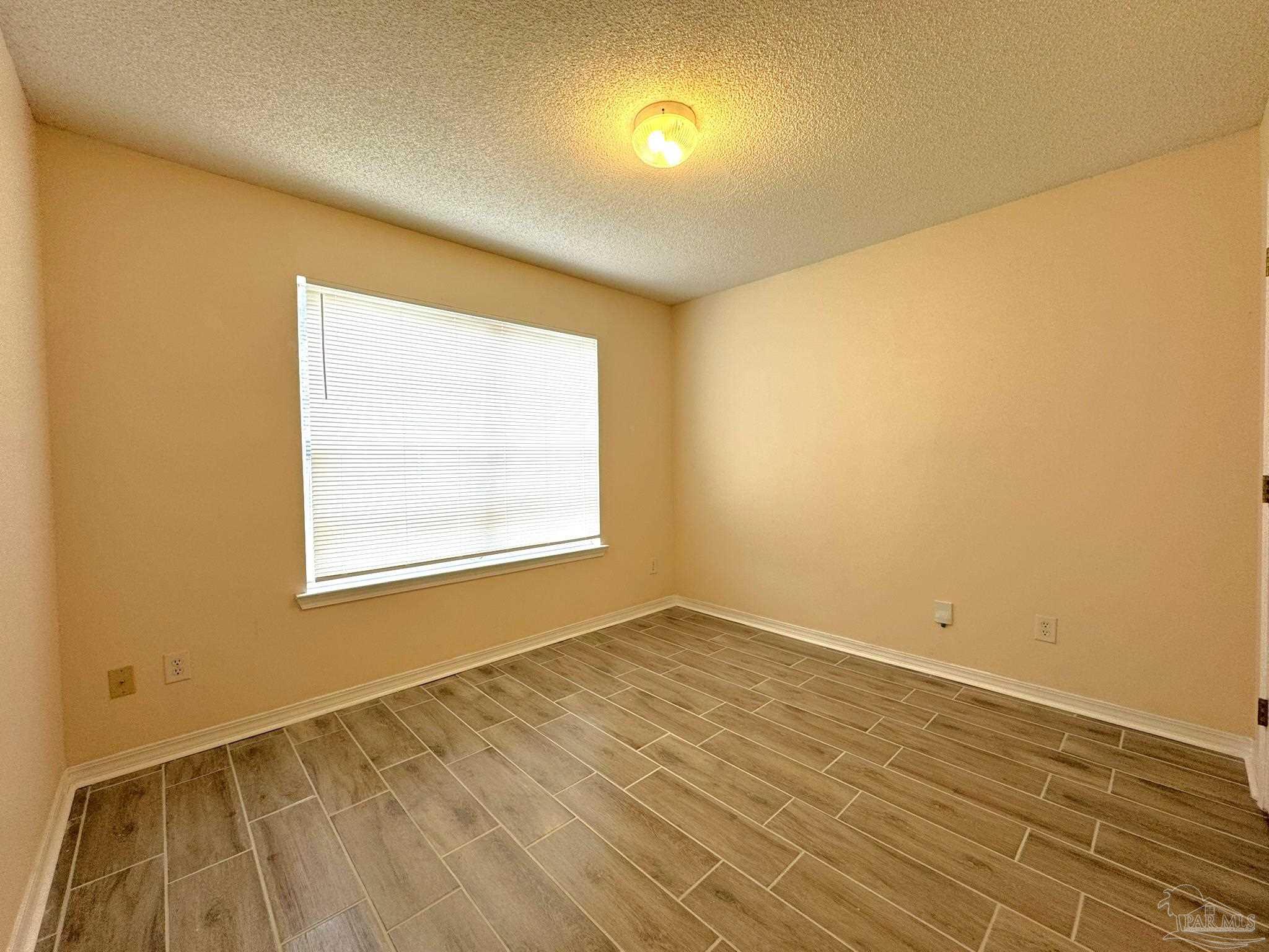 7972 Cayenne Way Pensacola, FL 32526 - Photo 5 of 11 a view of an empty room with wooden floor and a window
