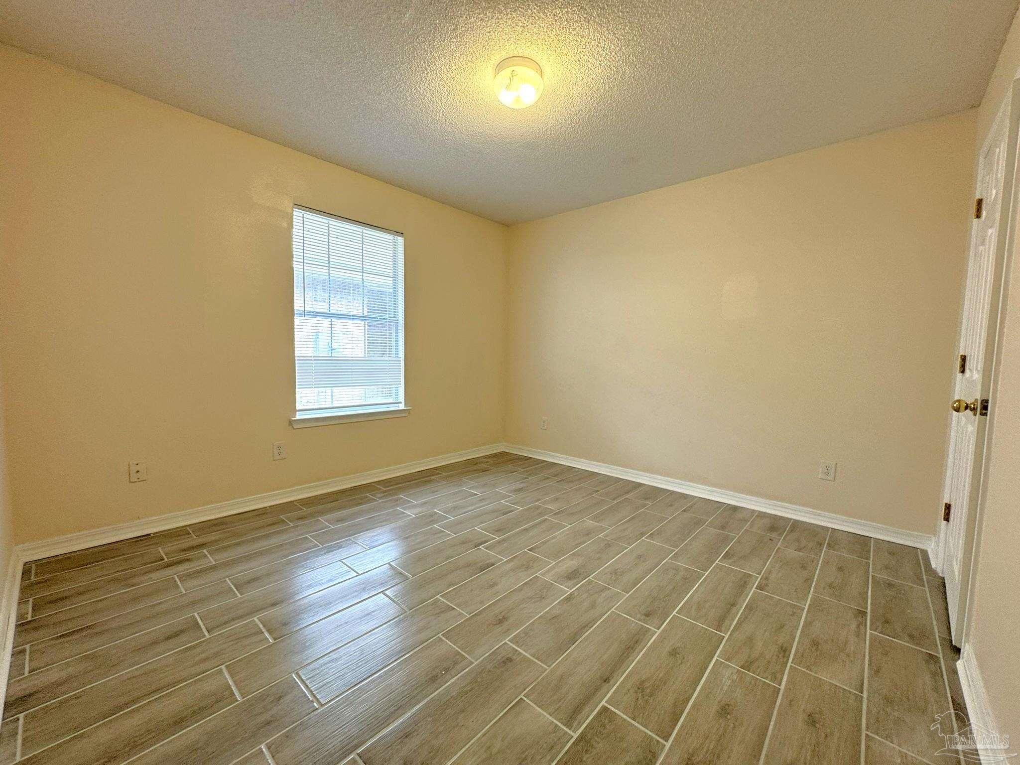 7972 Cayenne Way Pensacola, FL 32526 - Photo 6 of 11 an empty room with wooden floor and windows