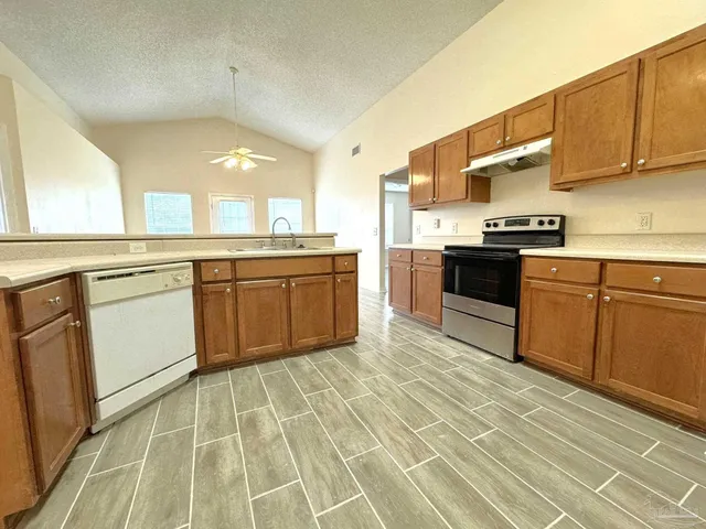 a kitchen with stainless steel appliances granite countertop a sink counter space cabinets and a large window