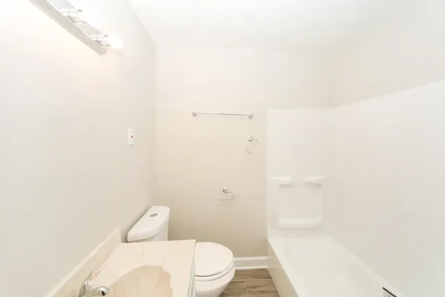 a front view of a house with a garden and lake view