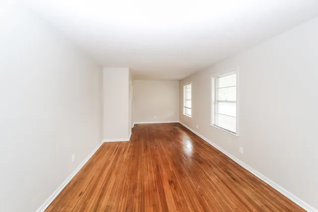 a view of a room with wooden floor and white walls
