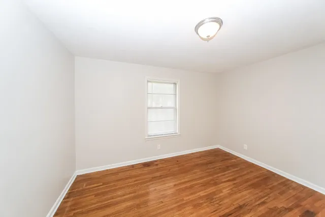 a view of a room with wooden floor and windows