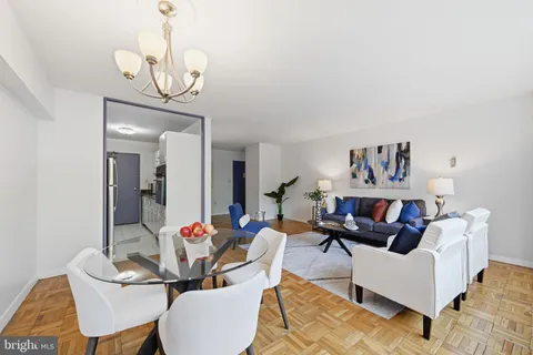 a living room with furniture a chandelier and a flat screen tv