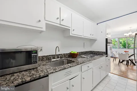 a kitchen with granite countertop a sink a stove and cabinets