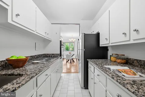 a kitchen with stainless steel appliances granite countertop a refrigerator and a stove