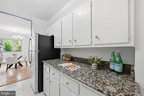 a kitchen with stainless steel appliances granite countertop a refrigerator sink and stove