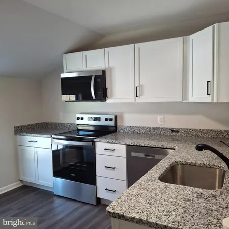 a kitchen with stainless steel appliances granite countertop a sink stove and microwave