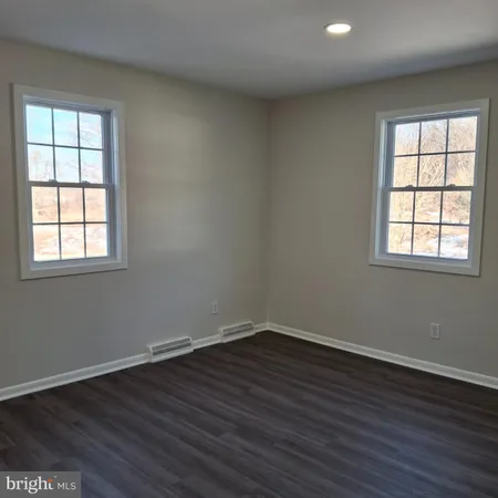 a view of a room with wooden floor and windows in it