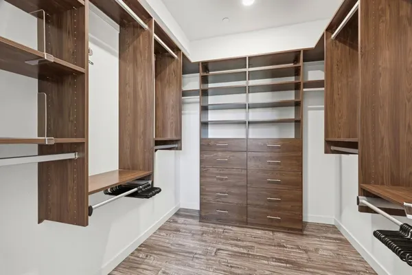 a view of walk in closet with clothes and shoes
