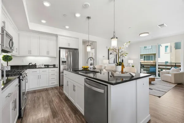 a kitchen with stainless steel appliances granite countertop a sink stove and refrigerator