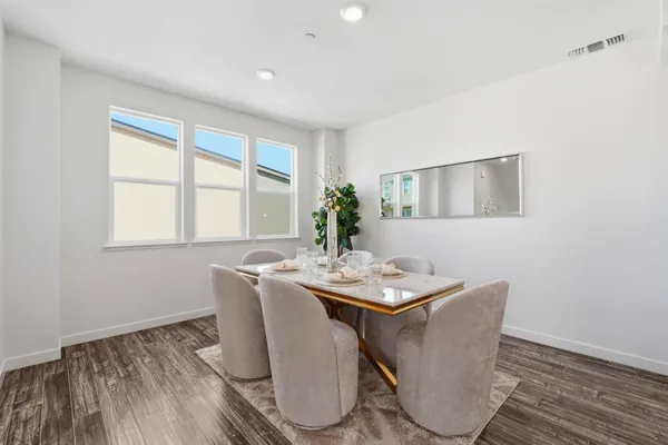 a dining room with furniture a window and wooden floor