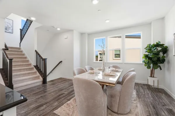 a dining room with furniture potted plants and wooden floor