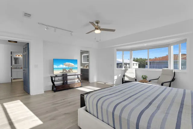 a bedroom with furniture and a large window