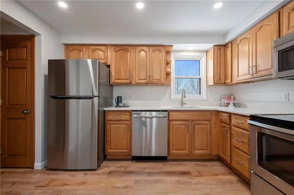 a kitchen with stainless steel appliances granite countertop a refrigerator stove top oven and sink
